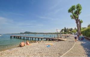 a group of people on a beach near the water at Villaggio Heliopolis in Manerba del Garda