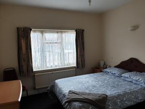 a bedroom with a bed and a window at Tower House Hotel in Reading