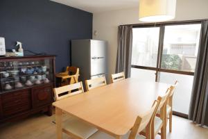 a dining room table with chairs and a refrigerator at Villa alive in Takekara