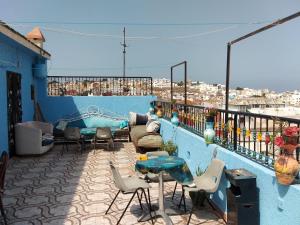 a balcony with chairs and tables on a blue wall at Hôtel Marrakech in Tangier