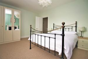 a bedroom with a bed with white sheets and a chandelier at Clifton House in Hereford