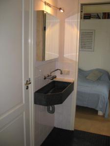 a bathroom with a black sink and a bed at Vakantiewoning "De Kei" in Warns