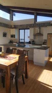 a large kitchen with a wooden table and a table and chairs at 91 Da Gama Beach House in Cape St Francis