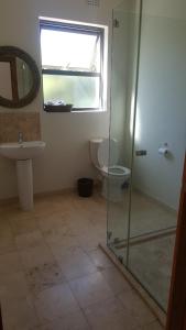 a bathroom with a toilet and a glass shower at 91 Da Gama Beach House in Cape St Francis +13 photos