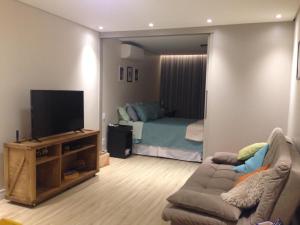 Charmoso e Confortável في برازيليا: غرفة معيشة مع أريكة وسرير
