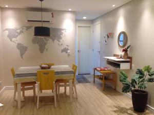 Charmoso e Confortável في برازيليا: غرفة طعام مع طاولة وخريطة عالم على الحائط