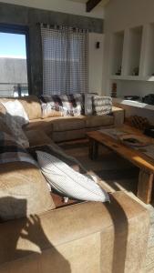 a living room with a couch and a table at 91 Da Gama Beach House in Cape St Francis