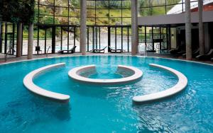 una piscina in un edificio con acqua blu di Le refuge de la Marmotte, Chalets du Bayle a Cauterets