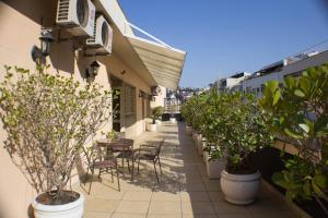 a patio with tables and chairs and potted plants at Hotel Regina Rio de Janeiro in Rio de Janeiro