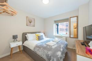 1 dormitorio con cama, escritorio y ventana en The Maltings en Edimburgo