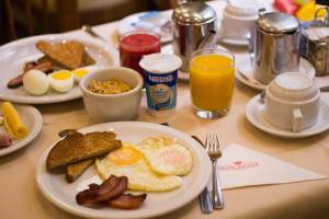 a breakfast table with eggs bacon and toast and orange juice at Hotel Regina Rio de Janeiro in Rio de Janeiro