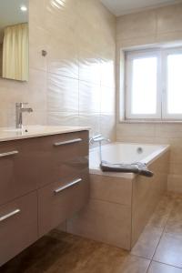 a bathroom with a tub and a sink and a window at Green Buda Valley: Holiday home with garden in Budapest +57 photos