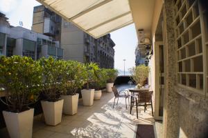 a balcony with chairs and potted plants on a building at Hotel Regina Rio de Janeiro in Rio de Janeiro