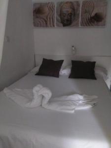 a white bed with towels on top of it at Laura Sunbeach in Alcudia