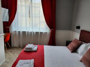 Schlafzimmer mit einem roten und weißen Bett und einem Fenster in der Unterkunft Dimorra Boutique Rooms in Neapel