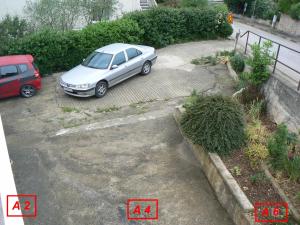 a white car parked in a parking lot at Apartmani David in Pula
