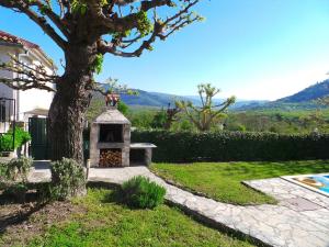einen Garten mit einem Baum und einem Steinkamin in der Unterkunft Guest House Valentino in Motovun