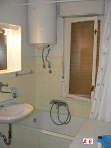 a bathroom with a sink and a bath tub at Apartmani David in Pula