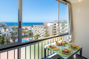 Un balcón con una mesa con comida y vistas al océano. en 928 Amazing View El Dorado, en Playa de las Américas