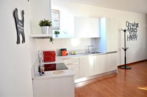 a kitchen with white cabinets and a red appliance at Tuttomondo in Pisa