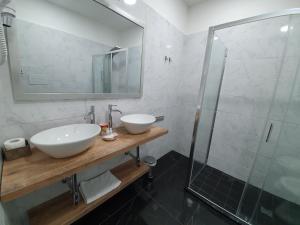 a bathroom with two sinks and a mirror at Dimorra Boutique Rooms in Naples