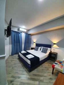 Schlafzimmer mit einem Kingsize-Bett und einem TV in der Unterkunft Dimorra Boutique Rooms in Neapel