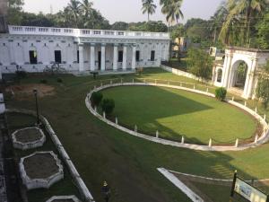 a large white building with a large yard at COSSIMBAZAR PALACE OF THE ROYS ( RAJBARI) in Cossimbāzār