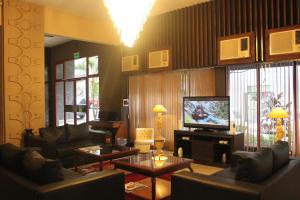 uma sala de estar com sofás de couro e uma televisão em Gran Hotel Parana em Assunção