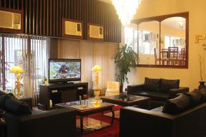 sala de estar con sofás y TV de pantalla plana. en Gran Hotel Parana, en Asunción
