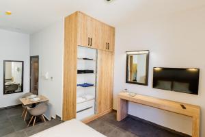 a bedroom with a tv and a wooden cabinet at G Suites Luxury Rentals in Lefkosa Turk