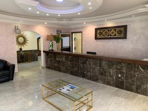a lobby with a counter and a glass table at class hotel in Brazzaville