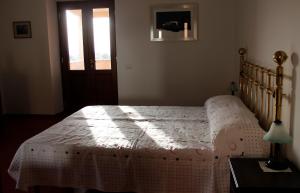 a bedroom with a bed with a white comforter at Appartamento in Villa Santa Caterina in Frascati