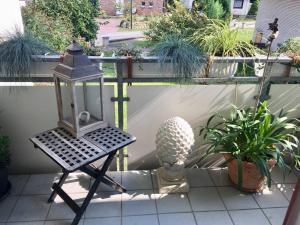 eine Laterne auf einer Terrasse mit Pflanzen in der Unterkunft Vitamine Sea Appartament/61m2 Haffkrug/Scharbeutz in Scharbeutz