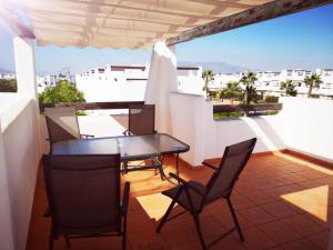a balcony with a table and chairs on a roof at Condado de Alhama Jardin 13 Appartement 1506 in El Romero
