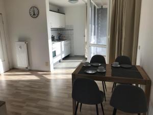 a kitchen and dining room with a table and chairs at Hafen-Apartment Aurich in Aurich