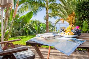 a table with a bowl of fruit and a book at Quinta Golfinho in Arco da Calheta