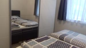 1 dormitorio con 2 camas y espejo en Ferienwohnung Weiss, en Waidring