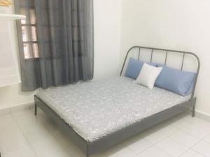 1 cama con 2 almohadas azules en una habitación en Home2Stay Damia @ Bukit Katil en Melaka