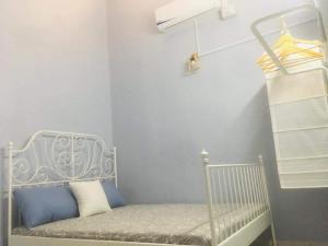 a white crib in a room with a shelf at Home2Stay Damia @ Bukit Katil in Malacca