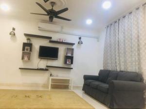 a living room with a couch and a flat screen tv at Home2Stay Damia @ Bukit Katil in Malacca