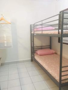a room with two bunk beds with pink pillows at Home2Stay Damia @ Bukit Katil in Malacca