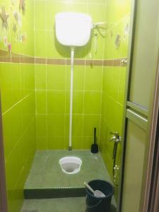 a green tiled bathroom with a toilet in the floor at Home2Stay Damia @ Bukit Katil in Malacca