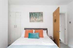 チェスターにあるSecret City Courtyard Cottage Within Chester City Wallsのベッドルーム1室(オレンジと青の枕が付いたベッド1台付)