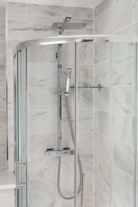 a shower in a bathroom with white marble walls at Secret City Courtyard Cottage Within Chester City Walls in Chester +22 photos