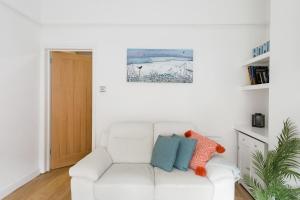 a white couch with two pillows on it in a living room at Secret City Courtyard Cottage Within Chester City Walls in Chester