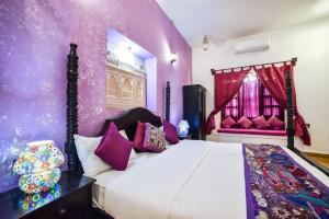 1 dormitorio con 1 cama con paredes moradas en Hotel Heritage House, en Jaisalmer