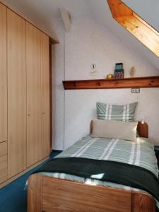 Schlafzimmer mit einem Bett mit einem Kopfteil aus Holz in der Unterkunft Ferienwohnung Wilhelm in Springstille