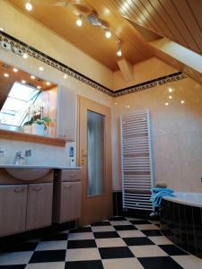 ein Badezimmer mit einer Badewanne, einem Waschbecken und einem Spiegel in der Unterkunft Ferienwohnung Wilhelm in Springstille