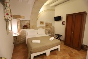 une chambre avec un lit avec deux serviettes dessus dans l'établissement Italiana Resort Magnolia, à Syracuse