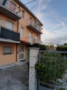 un immeuble d'appartements avec une clôture devant lui dans l'établissement A due passi dal mare, à Marina di Carrara